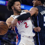 
              Detroit Pistons guard Cade Cunningham (2) passes around the defense of Orlando Magic forward Paolo Banchero (5) during the first half of an NBA basketball game, Wednesday, Oct. 19, 2022, in Detroit. (AP Photo/Carlos Osorio)
            