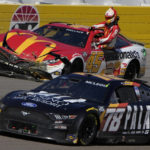 
              Bubba Wallace gets out of his car after crashing during a NASCAR Cup Series auto race Sunday, Oct. 16, 2022, in Las Vegas. (AP Photo/John Locher)
            