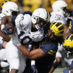 
              Michigan linebacker Mike Morris (90) tackles Penn State running back Nicholas Singleton (10) in the first half of an NCAA college football game in Ann Arbor, Mich., Saturday, Oct. 15, 2022. (AP Photo/Paul Sancya)
            