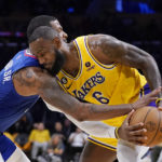 
              Los Angeles Clippers forward Marcus Morris Sr., left, reaches in on Los Angeles Lakers forward LeBron James during the second half of an NBA basketball game Thursday, Oct. 20, 2022, in Los Angeles. (AP Photo/Mark J. Terrill)
            