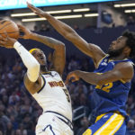 
              Denver Nuggets guard Kentavious Caldwell-Pope, left, shoots against Golden State Warriors forward Andrew Wiggins during the first half of an NBA basketball game in San Francisco, Friday, Oct. 21, 2022. (AP Photo/Jeff Chiu)
            