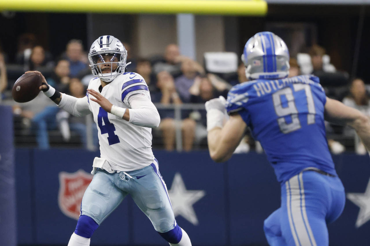 Dallas Cowboys quarterback Dak Prescott (4) is pressured by Detroit Lions defensive end Aidan Hutch...