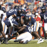 
              Virginia defenders gang tackle a Louisville player during an NCAA college football game in Charlottesville, Va., Saturday, Oct. 8, 2022. (Mike Kropf/The Daily Progress via AP)
            