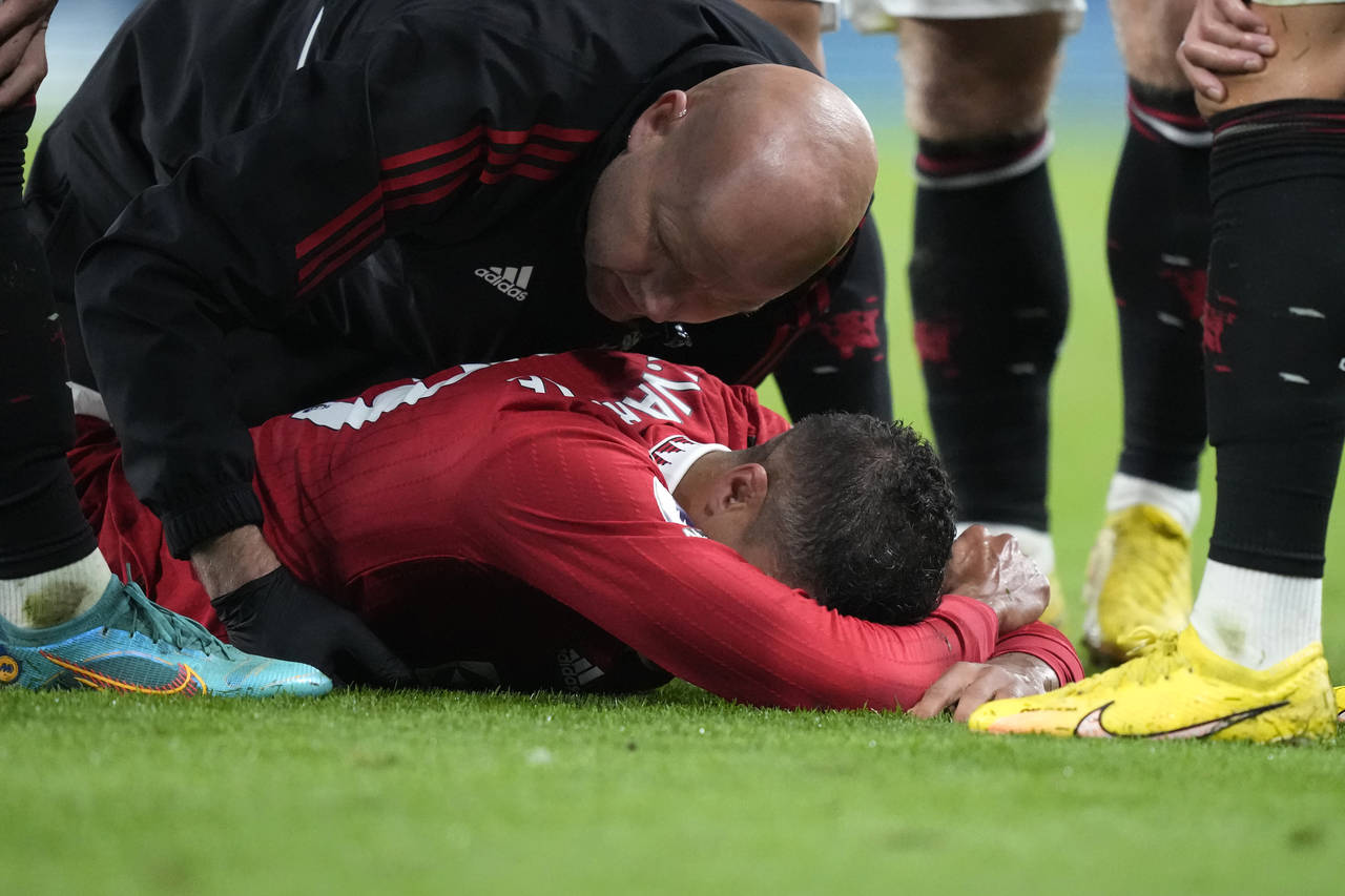 Manchester United's Raphael Varane lies injured on the ground during the English Premier League soc...