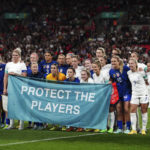 
              England and US teams stand together with a banner as a show of solidarity for victims of abuse before the women's friendly soccer match between England and the US at Wembley stadium in London, Friday, Oct. 7, 2022. (Nick Potts/PA via AP)
            