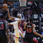 
              Miami Heat guard Gabe Vincent, center, goes up for a shot against Toronto Raptors forward Pascal Siakam (43) and guard Dalano Banton (45) during the first half of an NBA basketball game, Monday, Oct. 24, 2022, in Miami. (AP Photo/Wilfredo Lee)
            