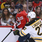 
              Washington Capitals center Lars Eller (20) and Boston Bruins defenseman Hampus Lindholm (27) vie for the puck during the first period of an NHL hockey game, Wednesday, Oct. 12, 2022, in Washington. (AP Photo/Nick Wass)
            