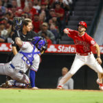 
              Los Angeles Angels' Livan Soto, right, reacts after he scored against Texas Rangers catcher Jonah Heim, left, during the seventh inning of a baseball game in Anaheim, Calif., Saturday, Oct. 1, 2022. (AP Photo/Ringo H.W. Chiu)
            