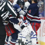 
              Winnipeg Jets' Pierre-Luc Dubois (80) and Toronto Maple Leafs' Auston Matthews (34) and Rasmus Sandin (38) tussle during the second period of an NHL hockey game Saturday, Oct. 22, 2022, in Winnipeg, Manitoba. (John Woods/The Canadian Press via AP)
            