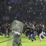 
              Soccer fans enter the pitch during a clash between supporters at Kanjuruhan Stadium in Malang, East Java, Indonesia, Saturday, Oct. 1, 2022. Clashes between supporters of two Indonesian soccer teams in East Java province killed over 100 fans and a number of police officers, mostly trampled to death, police said Sunday. (AP Photo/Yudha Prabowo)
            