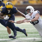 
              Michigan running back Blake Corum (2) bounces off the tackle of Penn State linebacker Tyler Elsdon (43) in the first half of an NCAA college football game in Ann Arbor, Mich., Saturday, Oct. 15, 2022. (AP Photo/Paul Sancya)
            