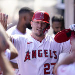 
              Los Angeles Angels' Mike Trout (27) celebrates in the dugout after scoring off of a single hit by Taylor Ward during the first inning of a baseball game against the Texas Rangers in Anaheim, Calif., Sunday, Oct. 2, 2022. (AP Photo/Ashley Landis)
            