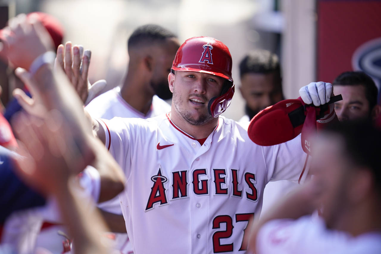Los Angeles Angels' Mike Trout (27) celebrates in the dugout after scoring off of a single hit by T...