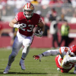 
              San Francisco 49ers running back Christian McCaffrey (23) runs in front of Kansas City Chiefs defensive end Frank Clark (55) during the first half of an NFL football game in Santa Clara, Calif., Sunday, Oct. 23, 2022. (AP Photo/Godofredo A. Vásquez)
            