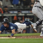 
              Seattle Mariners' Dylan Moore, left, slides safely into home plate to score a run on a hit by Adam Frazier off Detroit Tigers starting pitcher Bryan Garcia during the fifth inning of a baseball game, Monday, Oct. 3, 2022, in Seattle. (AP Photo/Stephen Brashear)
            