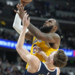 
              Los Angeles Lakers forward LeBron James, back, drives to the rim as Denver Nuggets guard Christian Braun defends in the second half of an NBA basketball game Wednesday, Oct. 26, 2022, in Denver. (AP Photo/David Zalubowski)
            