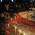 
              A man sprinkles flowers during a candle light vigil for the victims of Saturday's soccer riots, in Jakarta, Indonesia, Sunday, Oct. 2, 2022. Panic and a chaotic run for exits after police fired tear gas at an Indonesian soccer match in East Java to drive away fans upset with their team's loss left a large number of people dead, most of whom were trampled upon or suffocated. (AP Photo/Dita Alangkara)
            