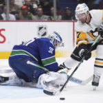 
              Pittsburgh Penguins' Jeff Carter (77) loses control of the puck on a breakaway against Vancouver Canucks goalie Spencer Martin (30) during the second period of an NHL hockey game in Vancouver, British Columbia on Friday, Oct. 28, 2022. (Darryl Dyck/The Canadian Press via AP)
            
