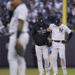 
              New York Yankees center fielder Aaron Hicks is helped off the field by manager Aaron Boone after colliding with Oswaldo Cabrera during the third inning of Game 5 of an American League Division baseball series against the Cleveland Guardians, Tuesday, Oct. 18, 2022, in New York.(AP Photo/Frank Franklin II)
            
