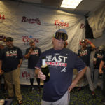 
              Atlanta Braves manager Brian Snitker, center, talks to players as they celebrate in the club house after clinching their fifth consecutive NL East title by defeating the Miami Marlins 2-1, in a baseball game, Tuesday, Oct. 4, 2022, in Miami. (AP Photo/Wilfredo Lee)
            