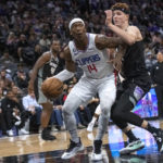 
              Los Angeles Clippers guard Terance Mann (14) is guarded by Sacramento Kings guard Kevin Huerter during the second half of an NBA basketball game in Sacramento, Calif., Saturday, Oct. 22, 2022. The Clippers won 111-109. (AP Photo/Randall Benton)
            