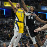 
              Indiana Pacers guard Tyrese Haliburton (0) shoots under the defense of San Antonio Spurs guard Devin Vassell (24) during the second half of an NBA basketball game in Indianapolis, Friday, Oct. 21, 2022. (AP Photo/AJ Mast)
            