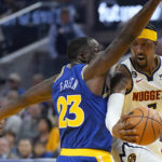 
              Denver Nuggets guard Kentavious Caldwell-Pope, right, passes the ball while defended by Golden State Warriors forward Draymond Green (23) during the first half of an NBA basketball game in San Francisco, Friday, Oct. 21, 2022. (AP Photo/Jeff Chiu)
            