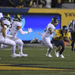 
              West Virginia's Preston Fox (29) recovers a fumbled punt return while defended by Baylor long snapper Garrison Grimes (26) during the first half of an NCAA college football game in Morgantown, W.Va., Thursday, Oct. 13, 2022. (AP Photo/Kathleen Batten)
            