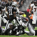 
              Denver Broncos running back Melvin Gordon III (25) fumbles the football as Las Vegas Raiders cornerback Amik Robertson (21) recovers during the first half of an NFL football game, Sunday, Oct. 2, 2022, in Las Vegas. Robertson run the fumble back for a touchdown. (AP Photo/David Becker)
            