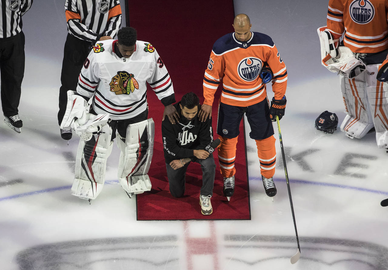 FILE - Minnesota Wild's Matt Dumba takes a knee during the national anthem flanked by Chicago Black...