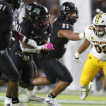 
              Hawaii running back Dedrick Parson (31) gets past Wyoming defensive end DeVonne Harris (93) to make a touchdown during the first half of an NCAA college football game on Saturday, Oct. 29, 2022, in Honolulu. (AP Photo/Marco Garcia)
            