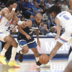
              Minnesota Timberwolvesguard Jordan McLaughlin, center, tries to push past Oklahoma City Thunder forwards Aaron Wiggins, left, and Jaylin Williams, right, in the first half of an NBA basketball game, Sunday, Oct. 23, 2022, in Oklahoma City. (AP Photo/Kyle Phillips)
            