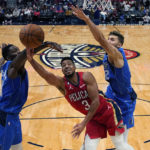 
              New Orleans Pelicans guard CJ McCollum (3) goes to the basket between Dallas Mavericks forwards Dorian Finney-Smith, left, and Maxi Kleber in the first half of an NBA basketball game in New Orleans, Tuesday, Oct. 25, 2022. (AP Photo/Gerald Herbert)
            