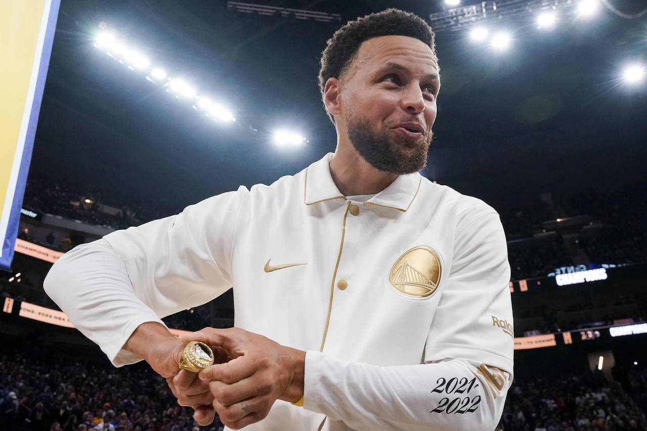 Golden State Warriors guard Stephen Curry reacts after receiving his 2021-2022 NBA championship rin...