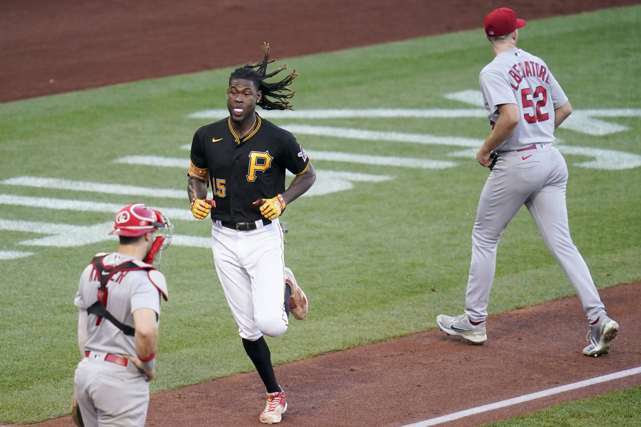 Pittsburgh Pirates' Oneil Cruz, center, heads home to score between St. Louis Cardinals starter Mat...