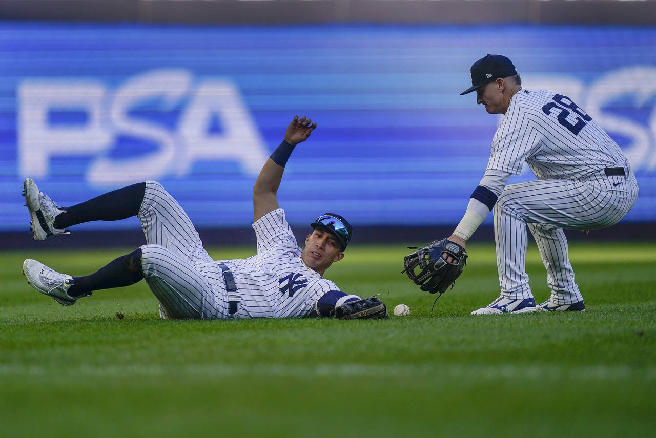 New York Yankees left fielder Oswaldo Cabrera, left, can't make the catch on a blooping base hit by...