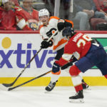 
              Philadelphia Flyers right wing Wade Allison (57) passes the puck past Florida Panthers defenseman Josh Mahura (28) during the second period of an NHL hockey game, Wednesday, Oct. 19, 2022, in Sunrise, Fla. (AP Photo/Wilfredo Lee )
            
