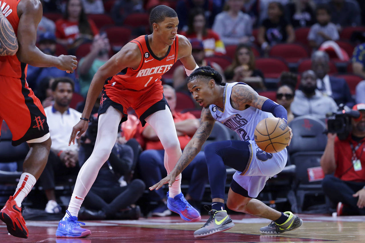 Memphis Grizzlies guard Ja Morant, right, loses his footing in front of Houston Rockets forward Jab...