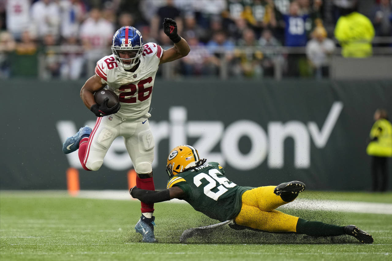 New York Giants running back Saquon Barkley (26) breaks away from Green Bay Packers safety Darnell ...
