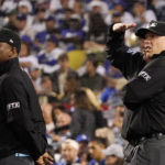 
              Umpires look toward the sky after a drone was seen above the field during the third inning of a baseball game between the Los Angeles Dodgers and the Colorado Rockies Tuesday, Oct. 4, 2022, in Los Angeles. The game was halted for several minutes due to the intrusion. (AP Photo/Mark J. Terrill)
            