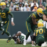 
              Green Bay Packers quarterback Aaron Rodgers (12) scrambles away from New York Jets defensive tackle Sheldon Rankins (98) during the first half of an NFL football game Sunday, Oct. 16, 2022, in Green Bay, Wis. (AP Photo/Matt Ludtke)
            