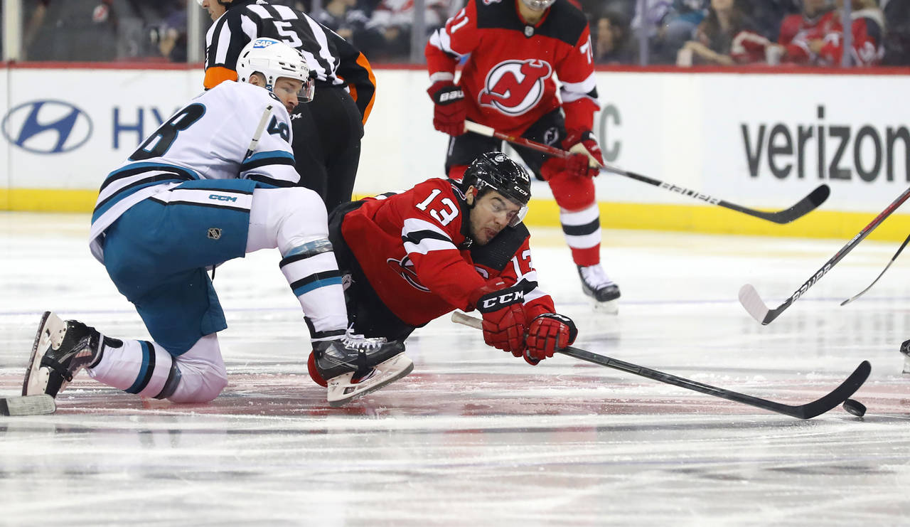 New Jersey Devils center Nico Hischier (13) plays the puck against San Jose Sharks center Tomas Her...
