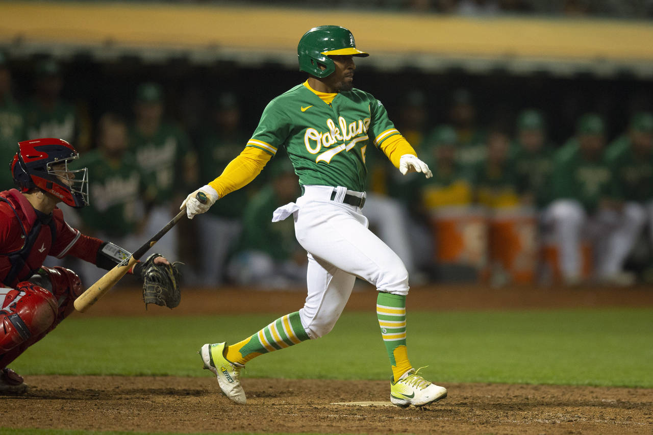 Oakland Athletics pinch hitter Tony Kemp (5) follows through on his game-winning single against the...