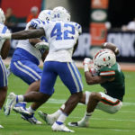 
              Miami running back Jaylan Knighton, right, fumbles the ball during the first half of an NCAA college football game against Duke, Saturday, Oct. 22, 2022, in Miami Gardens, Fla. The ball was recovered by Duke. (AP Photo/Wilfredo Lee)
            