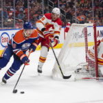 
              Calgary Flames Nikita Zadorov (16) chases Edmonton Oilers' Zach Hyman (18) as goalie Dan Vladar (80) looks for the puck during the second period of an NHL hockey game Saturday, Oct. 15, 2022, in Edmonton, Alberta. (Jason Franson/The Canadian Press via AP)
            