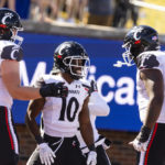 
              Cincinnati running back Charles McClelland (10) is congratulated by offensive linemen Joe Huber (60) and James Tunstall (72) after scoring a touchdown during the first half of an NCAA college football game against SMU, Saturday, Oct. 22, 2022, in Dallas. (AP Photo/Brandon Wade)
            