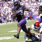 
              TCU running back Kendre Miller (33) escapes the grasp of Oklahoma defensive back Kani Walker (26) to score a touchdown during the first half of an NCAA college football game Saturday, Oct. 1, 2022, in Fort Worth, Texas. (AP Photo/Ron Jenkins)
            