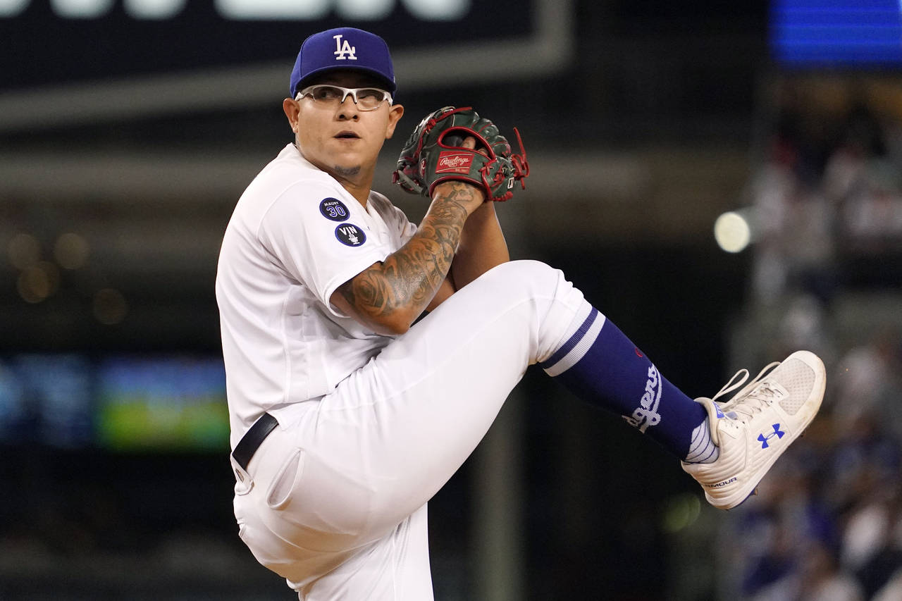 Los Angeles Dodgers starting pitcher Julio Urias throws to the plate during the first inning of a b...