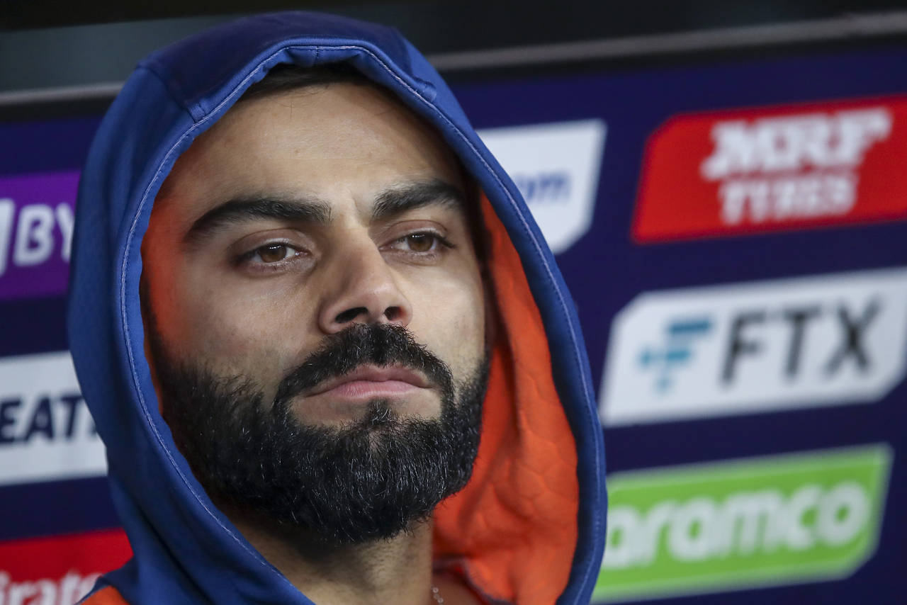 India's Virat Kohli watches play from the players dugout during the T20 World Cup cricket match bet...
