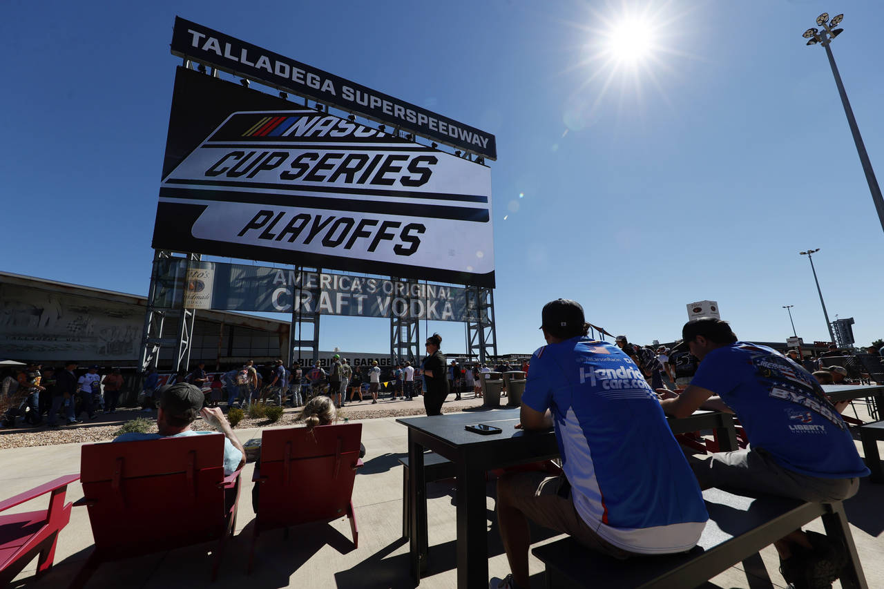 Fans eat and watch the big screen before the NASCAR Cup Series auto race Sunday, Oct. 2, 2022, in T...